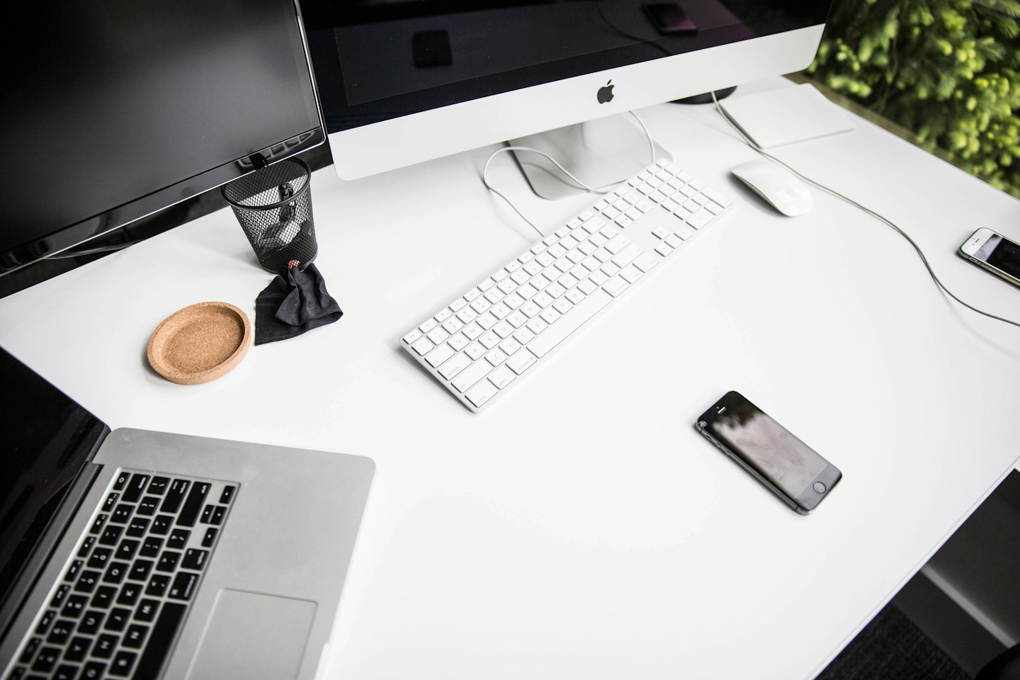 Modern white desk with open laptop and office supplies.