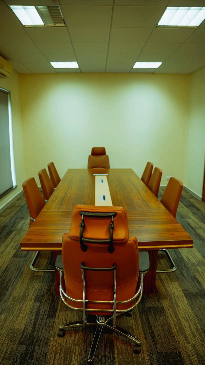 Empty conference room with a long table and office chairs.